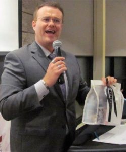 MC Justin Mazzatto auctions off a gift from Rinaldo’s at the CANHAVE Dinner at Restaurant International, Algonquin College.